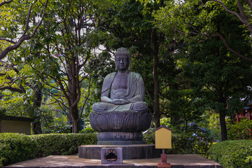 Buddha statue with crossed legs in a park in Tokyo