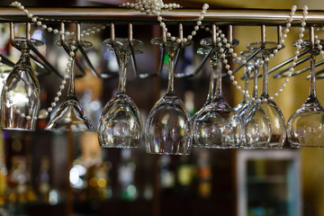 Empty glasses for wine above a bar rack