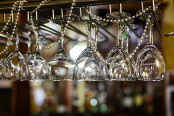 Empty glasses for alcohol beverage above a bar rack background