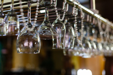 Empty glasses for alcohol beverage above a bar rack background