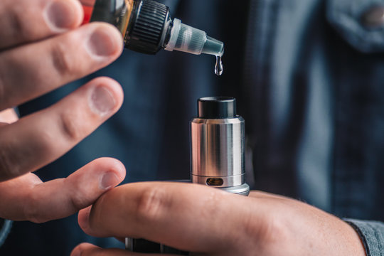 Man dripping his vape device, RDA or e-cigarette