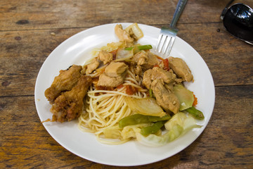 Traditional Thai food in a plate on a wooden outdoor table
