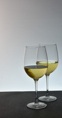 Two staggered glasses of white wine
