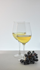 Two glasses of white wine with grapes