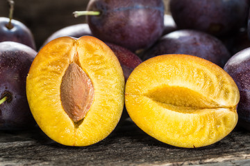 Fresh blue plums on wooden table