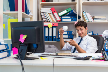 Businessman working in the office with piles of books and papers