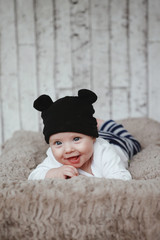 Closeup portrait of cute baby in black hat with ears