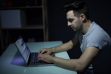 Caucasian hacker hacking the server in the dark