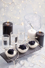 Festive buffet with vodka, black cavier and candles. Celebration concept for Christmas, new year or...