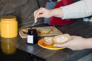 close up  woman hands with bread and jam. making toasts
