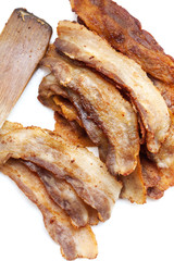 Fried pork bacon and wooden spatula on a white background
