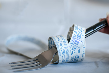 metro da sarta arrotolato su una forchetta come simbolo pesoforma