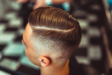 Hairdresser makes hairstyle a man with a beard