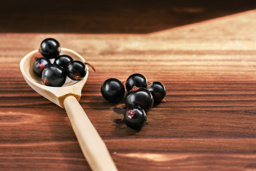 black currant berries in a wooden spoon