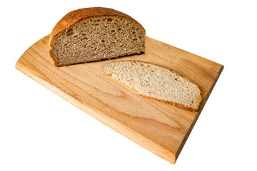 Bread on a cutting board. There is a cut piece of bread