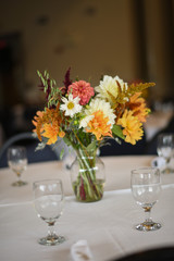 Obraz na płótnie Canvas Wedding Photography: Fall Wedding Centerpieces on a White Table Indoors