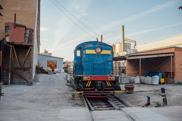 Industrial area of cement factory. Cargo locomotive on narrow gauge railway