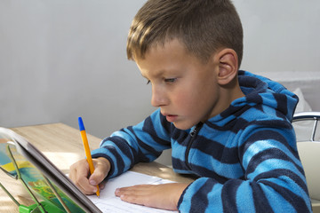 young kid, boy doing homework at home