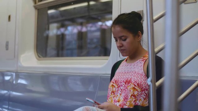 Woman using her Smartphone on New York Subway Train
