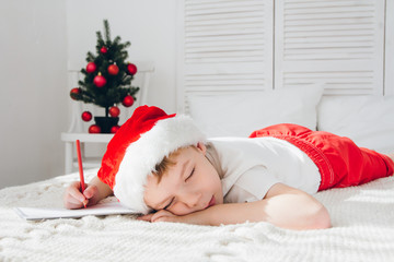 Fototapeta na wymiar Boy fell asleep writing letters to Santa