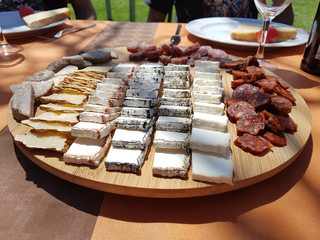 closeup of a plate with cheese (cheeseboard) and salami tipical Catalan food on a table on summer