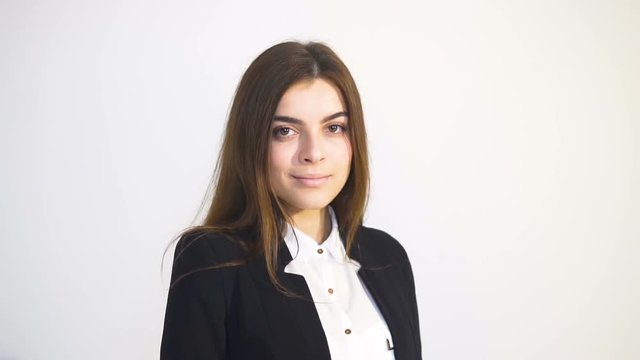 Portrait of smiling businesswoman, in white blouse and black jacket, isolated slowmotion in the white background
