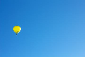 Yellow hot air ballon on blue sky.
