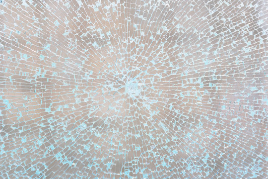 Cobweb of cracks on the broken glass in the shop window