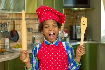 Black kid with cooking utensils. Boy in the kitchen. Basic cooking skills.