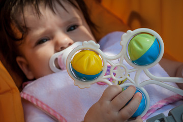 Baby with toy rattle