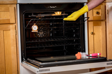 Lifting an oven rack out of the appliance with a yellow glove