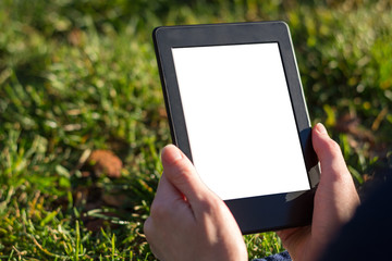 Fototapeta na wymiar Reading an ebook on a tablet in the park