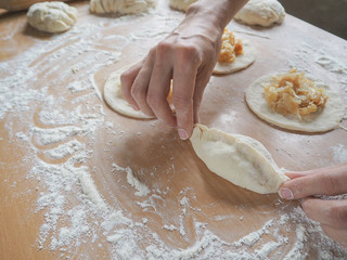 Raw pirozhki with cabbage in the cooking process.
