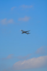Fototapeta na wymiar Big white airplane is the air, blue sky, cargo transportation or business travel