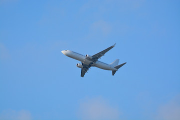 Fototapeta na wymiar Big white airplane is the air, blue sky, cargo transportation or business travel, copy space