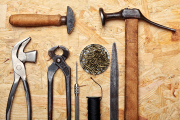 Set of cobbler vintage tools on the wooden background. Top view