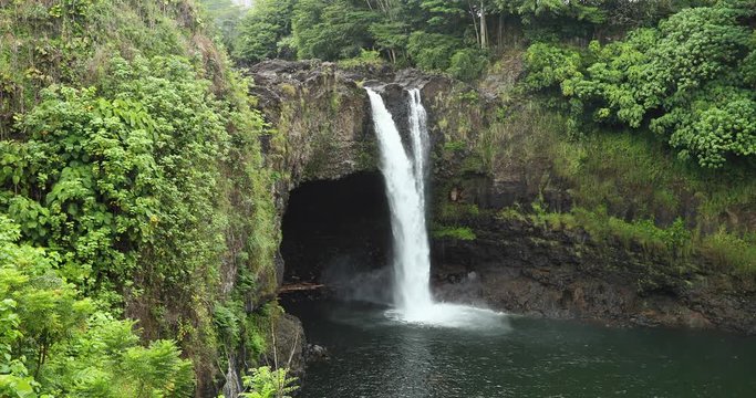 Rainbow Falls Hilo Hawaii tropical forest stream. Vacation and eco tourist destination. Big Island rain forest environment and landscape. River and stream with waterfalls. Beautiful green landscape.
