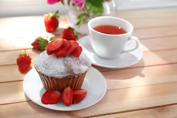 Delicious muffin and cup of tea on windowsill