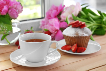 Delicious muffin and cup of tea on windowsill