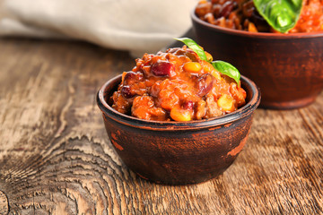 Chili con carne in bowls on wooden table