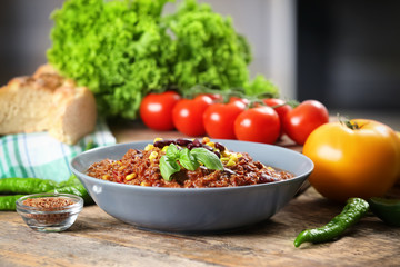 Bowl with delicious chili con carne on table