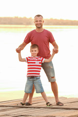 Cute boy with father on pier