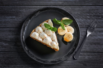 Plate with delicious banana cake on table