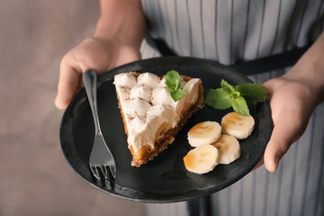 Woman holding plate with delicious banana cake, closeup