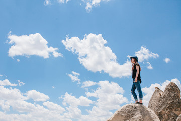 Young beautiful travel girl on top of a hill in Cappadocia, Turkey. Travel, success, freedom, achievement.
