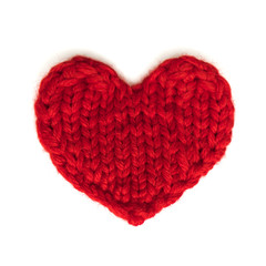 Red heart knitted from threads on a white background