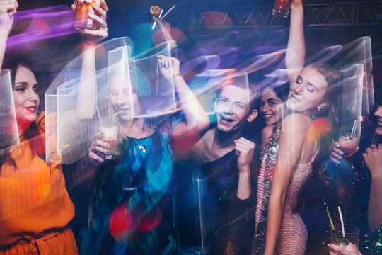 New Year dance party in motion. Happy friends company in night club, active Christmas celebration. Disco people in blurred colors, modern youth life, pickup concept