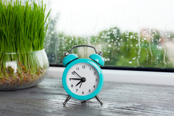 Alarm clock on wooden window sill. Morning routine concept