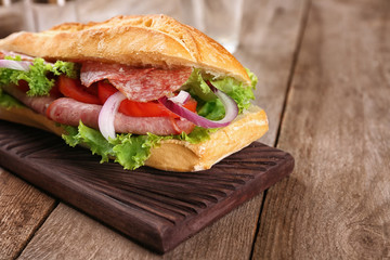 Delicious sausage sandwich on wooden board