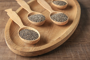 Spoons with chia seeds on wooden dish